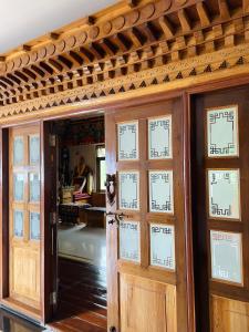 an entrance to a room with doors with writing on them at Martam Farmhouse in Pelling