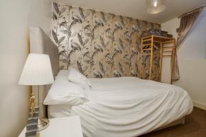 a bedroom with a white bed with a floral wallpaper at Pass the Keys 2 Bed Flat in Old School House in Lincoln