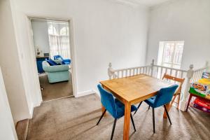 a dining room with a wooden table and blue chairs at Pass the Keys 2 Bed Flat in Old School House in Lincoln