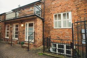 a brick building with a door and a balcony at Pass the Keys 2 Bed Flat in Old School House in Lincoln