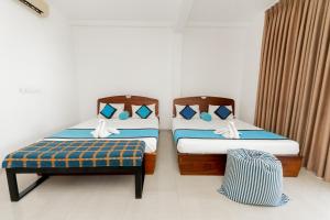 Hotel Vacanza في ميريسا: سريرين يجلسون بجانب بعض في غرفة