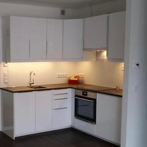 una cocina blanca con armarios blancos y fregadero en Appartement Feucht -Bhf 5 Min - Nähe Messe, en Feucht