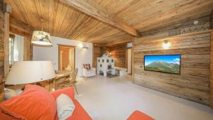 sala de estar con paredes de madera y TV de pantalla plana. en Chalet Stockerdörfl Apartment 68m2 by ONE-VILLAS, en Kitzbühel
