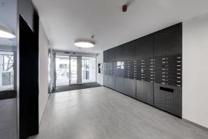 a hallway with black and white walls and tile floors at Holešovice Delight: Modern Comfort with a Twist in Prague 7 in Prague