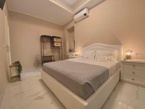 a white bedroom with a large bed and a dresser at Nido dei Cigni in Turin