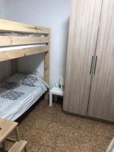 a bedroom with a bunk bed and a wooden cabinet at Cozy room in a shared apartment near the See Port Valencia in Valencia