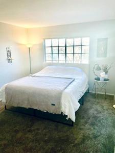 a bedroom with a large bed with a window at Gorgeous Serene Gated Newly Remodeled Townhouse in Las Vegas