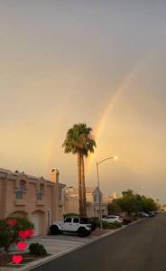 拉斯維加斯的住宿－Gorgeous Serene Gated Newly Remodeled Townhouse，一条棕榈树的街道上空的彩虹