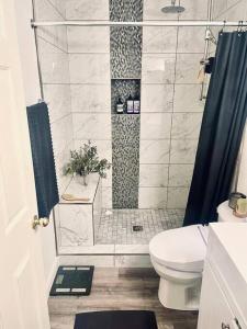 ein Bad mit einer Dusche, einem WC und einem Waschbecken in der Unterkunft Gorgeous Serene Gated Newly Remodeled Townhouse in Las Vegas