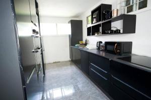 a kitchen with black cabinets and a stainless steel refrigerator at Holiday home in DʼArbeau