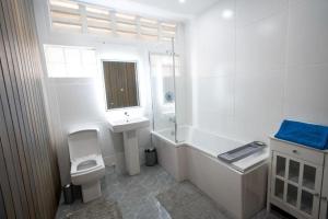 baño blanco con bañera, lavabo y aseo en Holiday home, en DʼArbeau