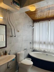 a bathroom with a toilet and a tub and a sink at Martam Farmhouse in Pelling