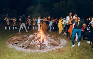 a group of people dancing around a fire pit at Elephant Hills Resort in Victoria Falls