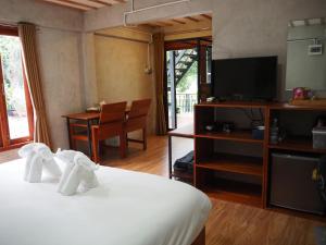 a hotel room with a bed and a television at Banmai87 Guest House บ้านไม้87 เกสต์เฮ้าส์ in Phra Nakhon Si Ayutthaya