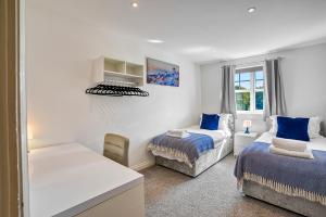 1 dormitorio blanco con 2 camas y ventana en Sandy Lane Apartment, en Skelmersdale