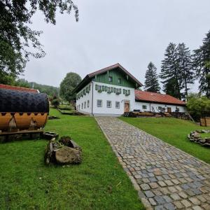 Landgut Michlshof - Bauernhof, Tinyhouse, Tiere في Untergriesbach: مبنى أبيض بسقف أخضر على ميدان عشبي
