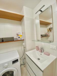 een badkamer met een wasmachine en een wastafel bij Nido della Regina in Turijn