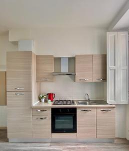 een keuken met houten kasten en een kookplaat met oven bij Nido della Regina in Turijn +4 foto's