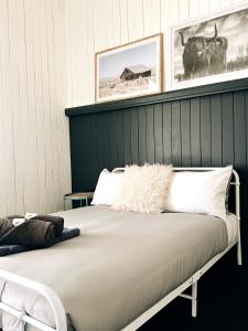 - un lit dans une chambre avec 2 photos sur le mur dans l'établissement The Stanley Hotel Kilcoy, à Kilcoy