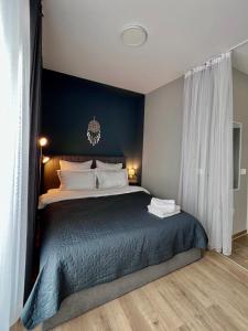 sypialnia z dużym łóżkiem z niebieską ścianą w obiekcie Blue Boho Studio Brasov with Terrasse and Panoramic view w Braszowie