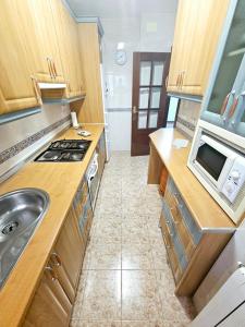 una pequeña cocina con fregadero y microondas en Piso Granada 3 dormitorios y parking privado, en Granada