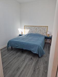 um quarto com uma cama e piso em madeira em La jolie Pradelle em Virsac