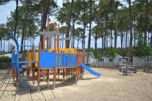 a playground with a slide in a park at Sbvacances Entièrement équipé et tout confort grand 2ch avec suite parentale et 2 sdb dans camping 4 étoiles in Saint-Julien-en-Born