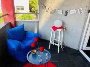 um pequeno quarto com um sofá azul e uma mesa em Apartman STUDIO Sch Sch Sch em Saraievo