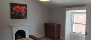 a bedroom with a fireplace and a dresser and a window at Eglinton Road - Super King - Ensuite in Bray