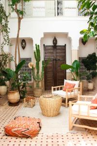 eine Terrasse mit vielen Pflanzen und Möbeln in der Unterkunft Riad Dar Nael in Marrakesch