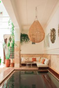 a pool in a living room with a couch and a light fixture at Riad Dar Nael in Marrakech