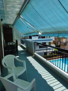 balcone con sedia e piscina di Etna Beach Home a Mascali