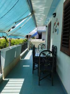 un tavolo e sedie sul balcone di una casa di Etna Beach Home a Mascali