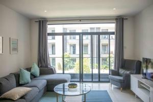 a living room with a couch and a large window at Cantonments 2 Bedroom at Embassy Gardens in Cantonments