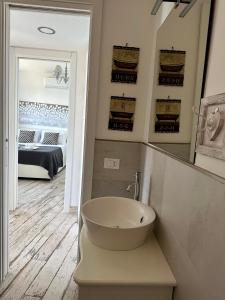 a bathroom with a bowl sink and a bedroom at Il bianconido in Castel Gandolfo