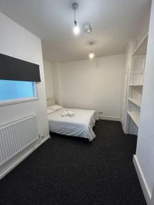 a small room with a bed and a book shelf at Spacious 5-Bedroom Urban Haven in Luton