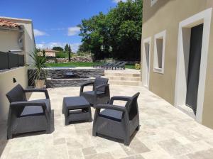 a patio with four chairs and a fountain at Apparts'hôtel la ferme du gros noyer in Malaucène