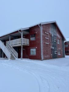 a red brick building in the snow with a staircase at Storhogna Torg in Vemdalen