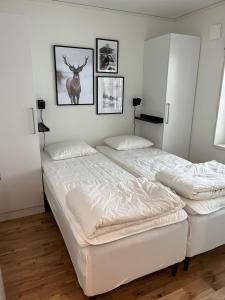 2 camas en un dormitorio con fotos en la pared en Storhogna Torg en Vemdalen