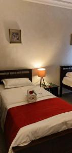 Tamrah Suites Hotel في عمّان: غرفة نوم بسرير كبير مع بطانية حمراء