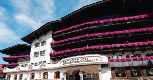 un edificio con fiori rosa sul lato di Hotel Das Walchsee a Walchsee