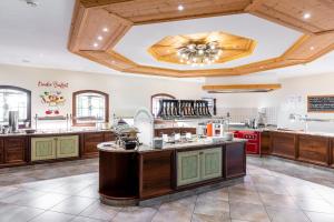 a large kitchen with wooden cabinets and a ceiling at Das Hopfgarten Familotel Tirol in Hopfgarten im Brixental