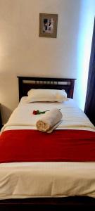 a bedroom with a bed with a red and white blanket at Tamrah Suites Hotel in Amman