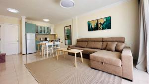 a living room with a couch and a kitchen at Sunset apart, large terrace, pool, Best location! in Puerto de Santiago