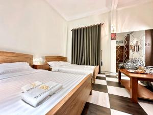 Habitación de hotel con 2 camas y escritorio en BÊ TÔNG RESIDENCES HOMESTAY en Can Tho