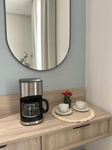 - une cafetière et 2 tasses sur une table avec un miroir dans l'établissement Modern Appartements With Private Entry, à Riyad