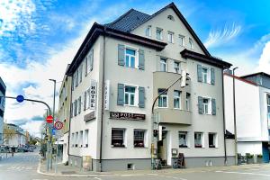 a white building on the corner of a street at Hotel Post Sindelfingen in Sindelfingen