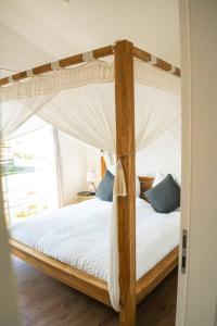 um quarto com uma cama de dossel em madeira com lençóis brancos e almofadas azuis em Kleine Auszeit em Unterwössen