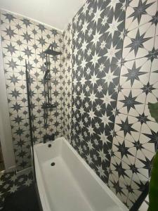 a bathroom with a white tub and black and white tiles at Modern 1 bed town centre apartment in Tamworth in Tamworth