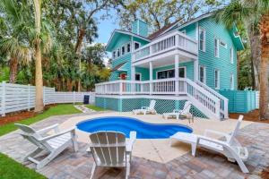 a blue house with a pool in front of it at 1 Egret Street N Forest Beach in Hilton Head Island